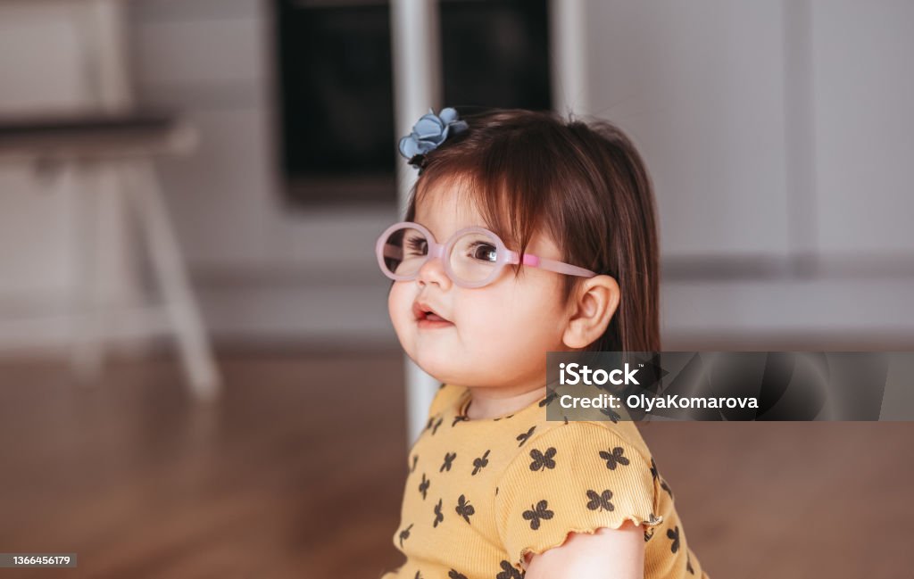 baby girl with poor eyesight.child with glasses.Cute  girl wearing glasses playing  happily