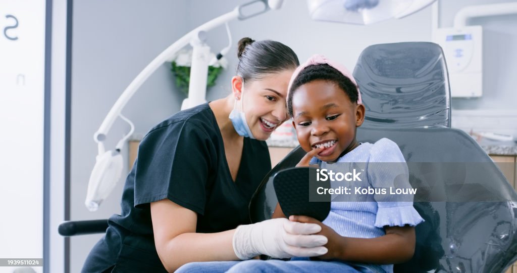 Dentist, child and healthcare with mirror for dental service, teeth whitening and oral hygiene or consultation. Dentistry, woman or kid patient for mouth wellness, tooth cleaning  and implant checkup
