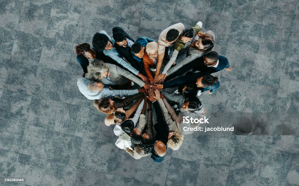 A diverse business group standing in a heart formation, symbolizing unity, teamwork, and collaboration.