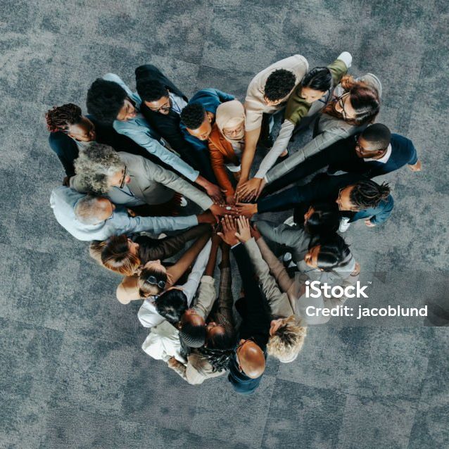A diverse business group standing in a heart formation, symbolizing unity, teamwork, and collaboration.
